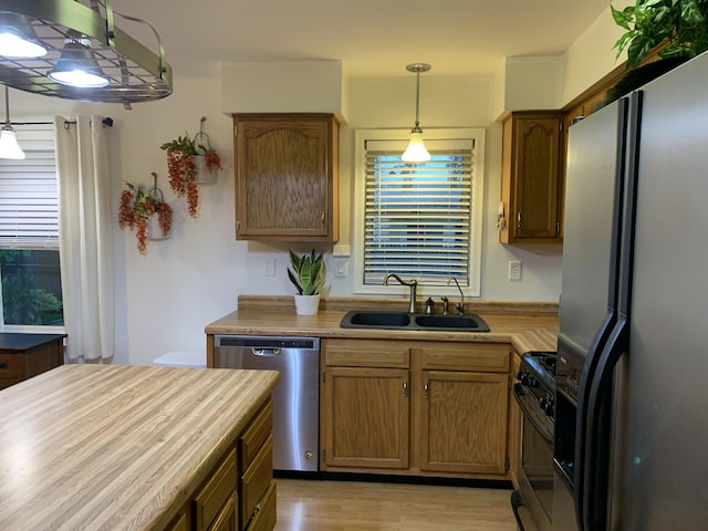 6645 Oak Dr, Celina, OH 45822 - kitchen with appliances with stainless steel finishes, hanging light fixtures, light wood-style floors, and brown cabinets