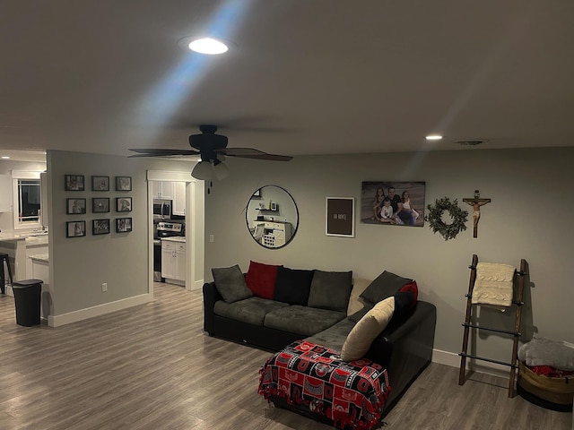 living room with baseboards, visible vents, wood finished floors, and recessed lighting