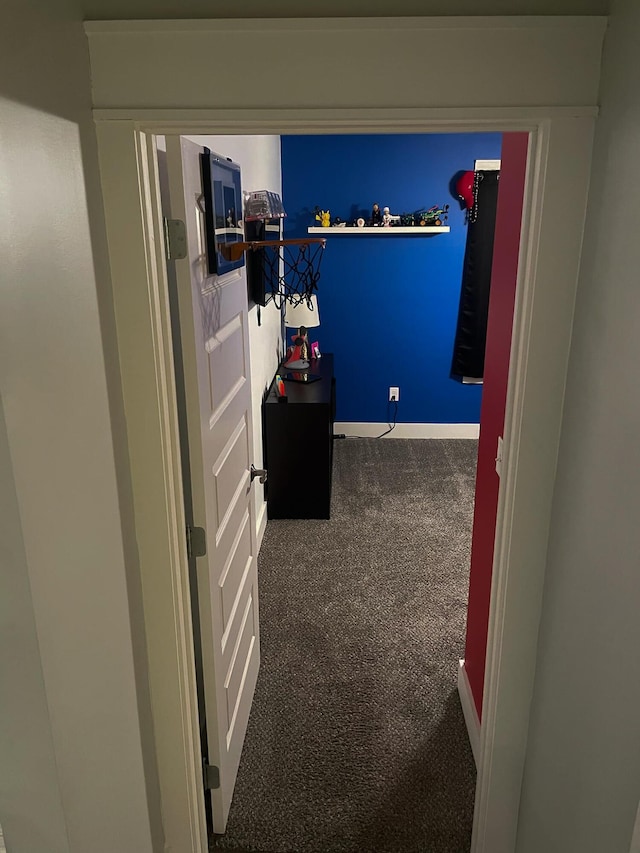 hallway featuring carpet flooring and baseboards