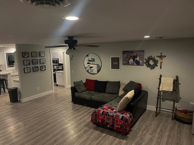 living room featuring visible vents, baseboards, and wood finished floors