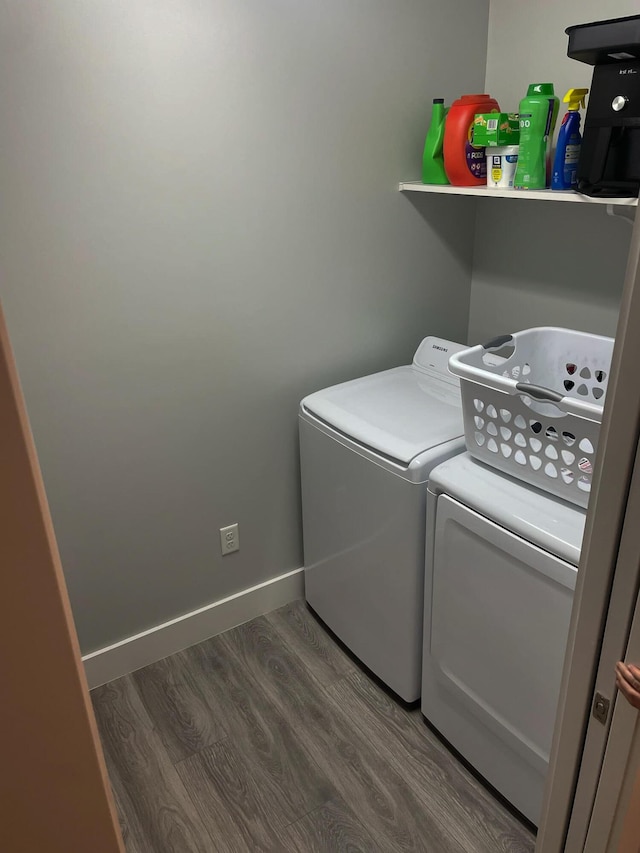 laundry room with laundry area, wood finished floors, washing machine and clothes dryer, and baseboards