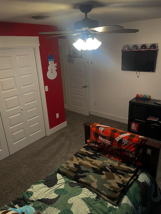 carpeted bedroom featuring a closet, ceiling fan, and baseboards