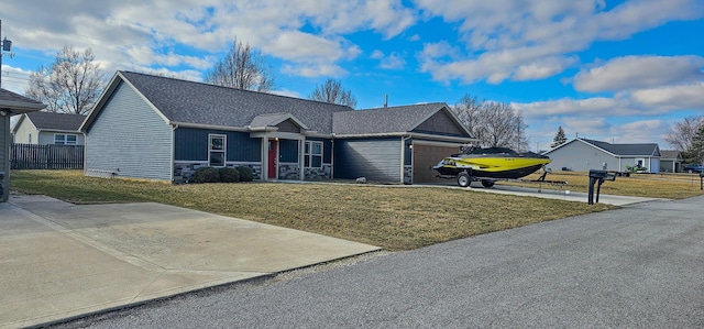 ranch-style home with concrete driveway, an attached garage, fence, stone siding, and a front lawn