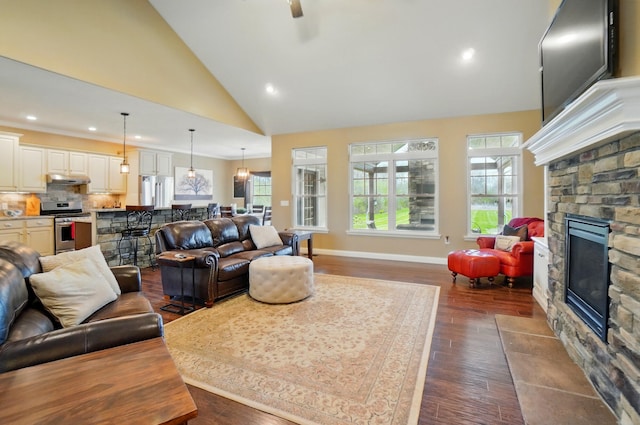 living area featuring baseboards, recessed lighting, a fireplace, a ceiling fan, and dark wood-type flooring