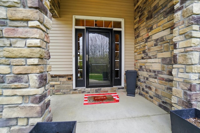 doorway to property with stone siding