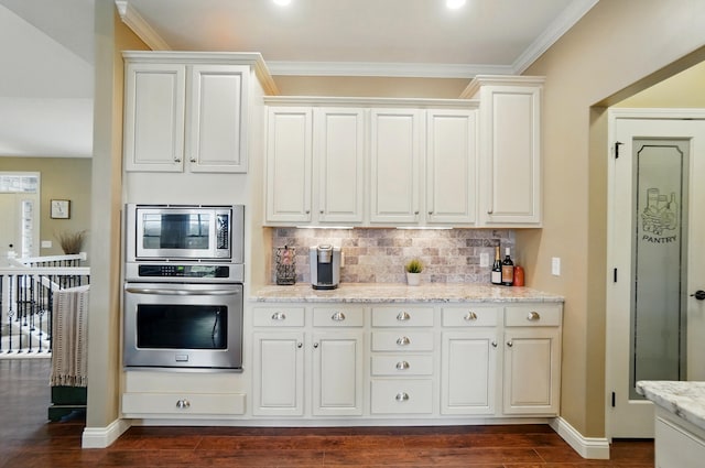 kitchen with dark wood-style flooring, ornamental molding, light stone counters, decorative backsplash, and stainless steel appliances