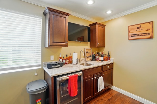 bar with indoor wet bar, dark wood-style flooring, a sink, beverage cooler, and baseboards