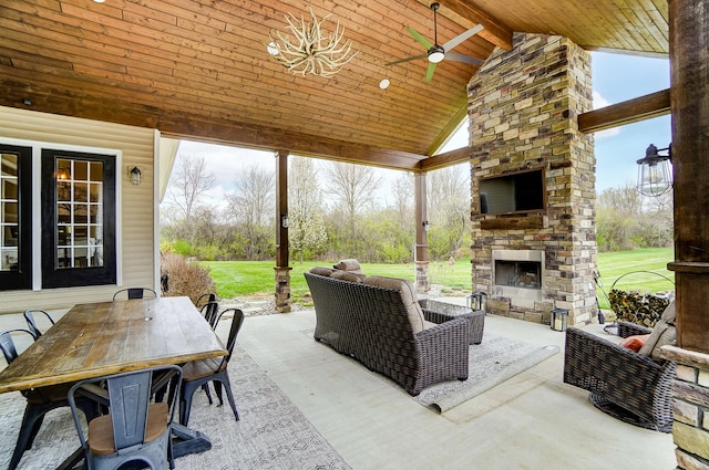 view of patio / terrace with a ceiling fan, outdoor dining area, and an outdoor stone fireplace