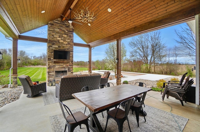 view of patio / terrace with outdoor dining area and an outdoor living space with a fireplace