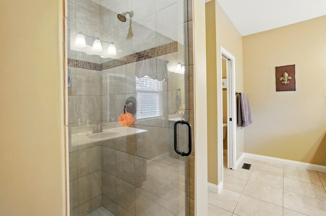 bathroom featuring tile patterned floors, a stall shower, and baseboards