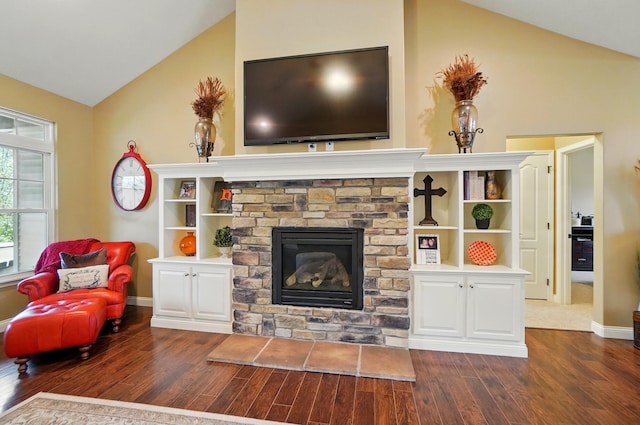living area featuring baseboards, a stone fireplace, dark wood finished floors, and lofted ceiling