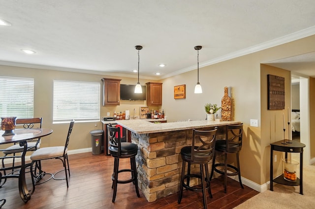 bar featuring indoor wet bar, baseboards, ornamental molding, dark wood-type flooring, and decorative light fixtures