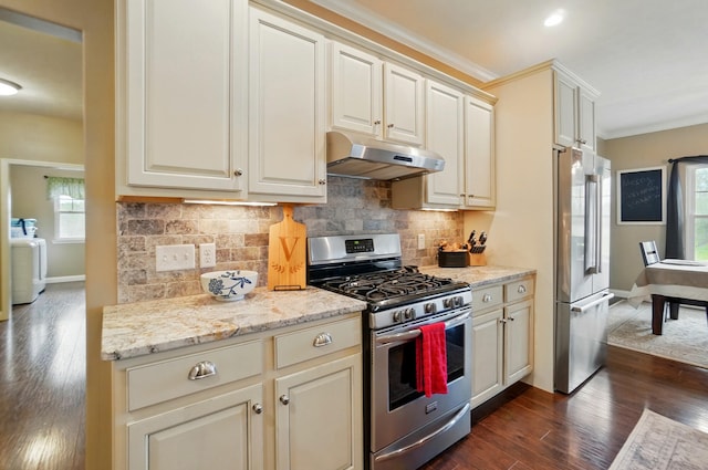 kitchen with washer / clothes dryer, baseboards, dark wood-style floors, under cabinet range hood, and appliances with stainless steel finishes