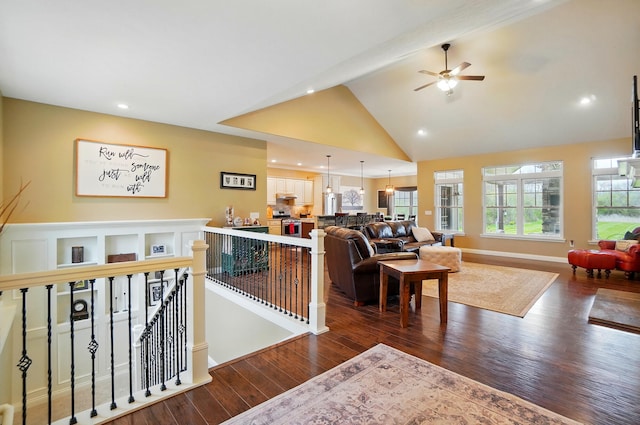living area featuring high vaulted ceiling, dark wood finished floors, a ceiling fan, recessed lighting, and beam ceiling