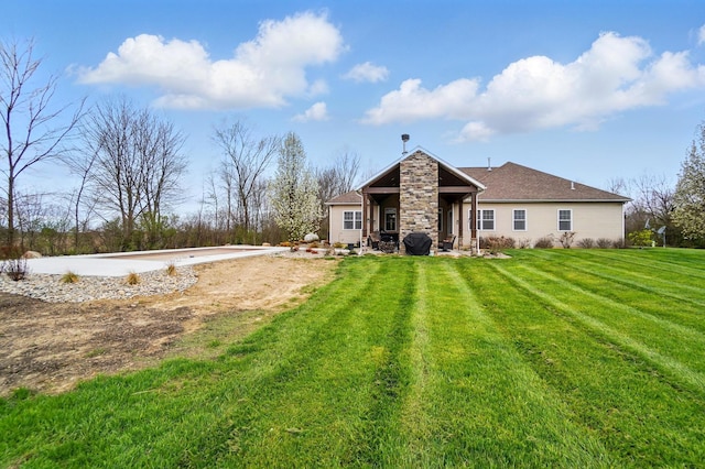 back of house with a yard and stone siding