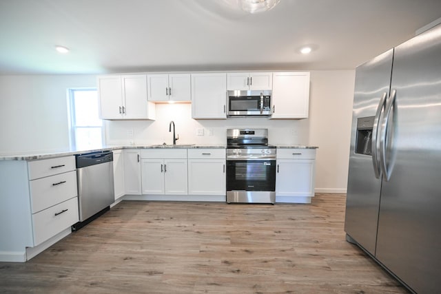 8095 N Lena-Palestine Rd, Conover, OH 45317 - kitchen with appliances with stainless steel finishes, white cabinets, light wood-style flooring, recessed lighting, and a peninsula