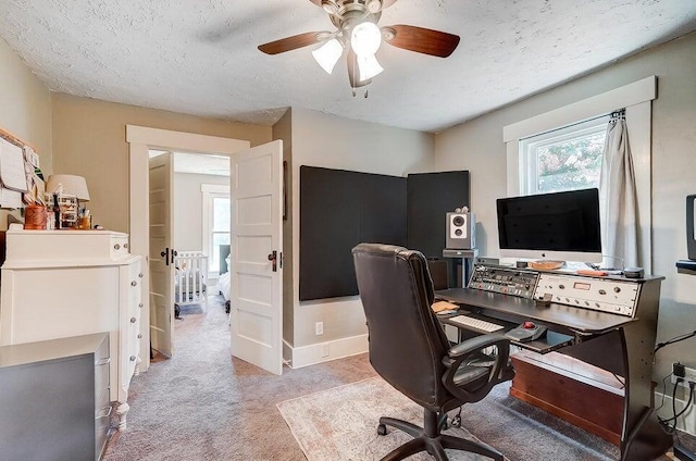 office area featuring ceiling fan, light colored carpet, and a textured ceiling