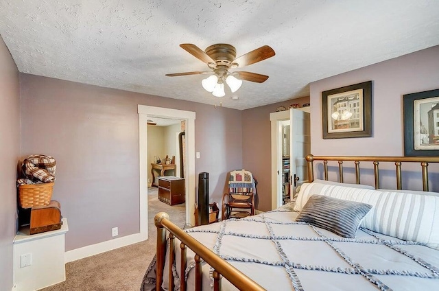 bedroom featuring light colored carpet, a textured ceiling, and ceiling fan