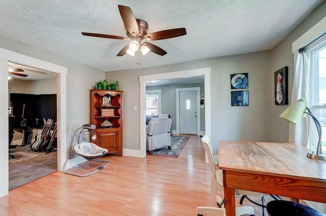 dining area with ceiling fan, plenty of natural light, light hardwood / wood-style floors, and a textured ceiling