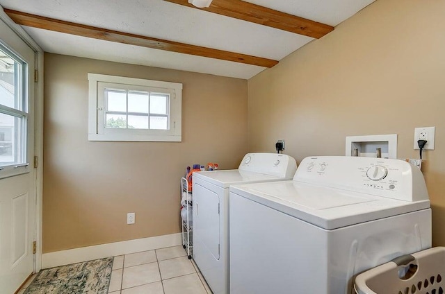 laundry room with light tile patterned floors, washer and dryer, and a healthy amount of sunlight