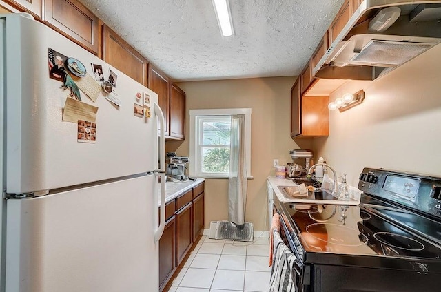 kitchen with sink, light tile patterned floors, black electric range, a textured ceiling, and white fridge