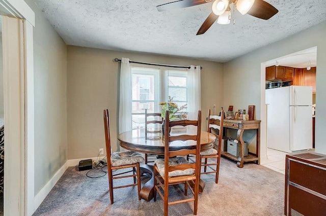 carpeted dining area with ceiling fan and a textured ceiling