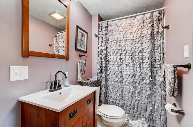 bathroom featuring vanity, toilet, and a textured ceiling