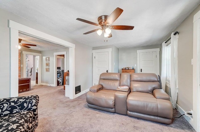 carpeted living room featuring a textured ceiling and ceiling fan