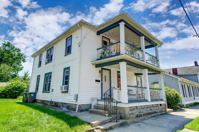 view of front of house with a front lawn, a balcony, and a porch