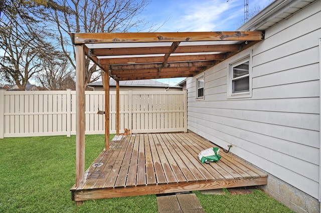 wooden terrace featuring a lawn and fence