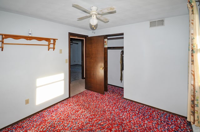 unfurnished bedroom featuring baseboards, visible vents, a ceiling fan, and carpet
