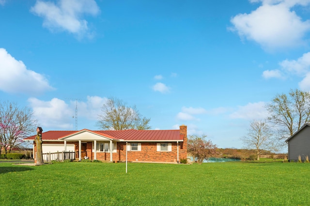 single story home featuring a chimney, a front lawn, and metal roof