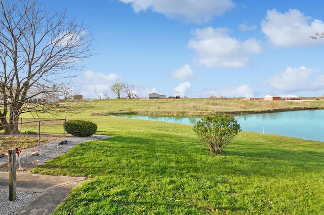 view of yard featuring a water view and fence
