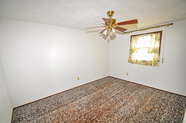 spare room with a ceiling fan, carpet, and baseboards