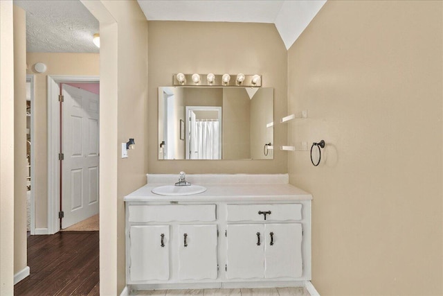 full bath featuring vanity, wood finished floors, and baseboards