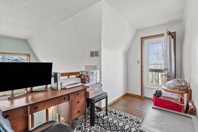 office area with vaulted ceiling, visible vents, a textured ceiling, and wood-type flooring