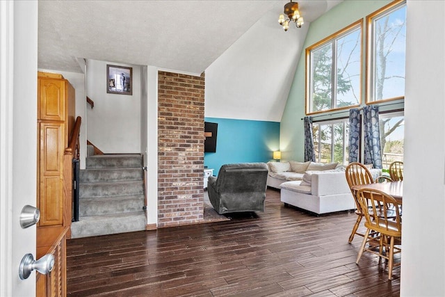 living room with stairway, a textured ceiling, dark wood-style floors, and high vaulted ceiling