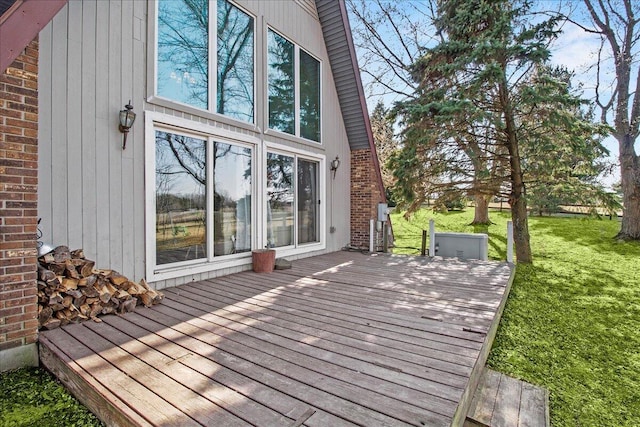 wooden terrace featuring a lawn