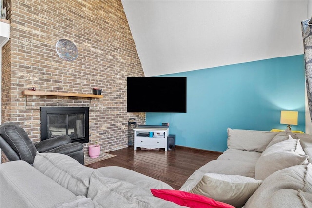 living area featuring baseboards, high vaulted ceiling, wood finished floors, and a fireplace