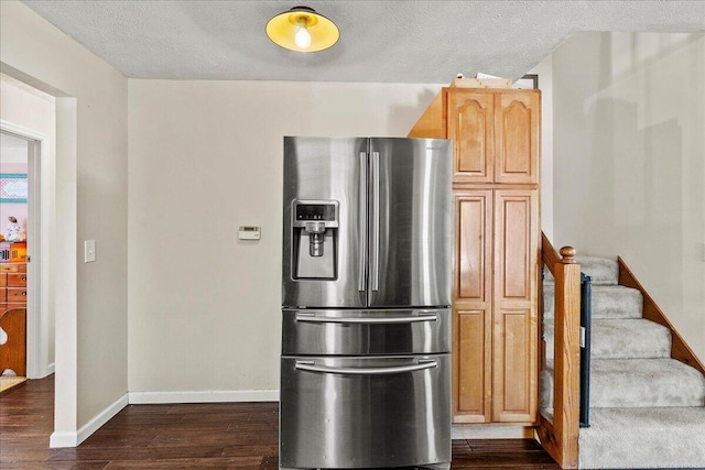 kitchen with baseboards, stainless steel fridge, a textured ceiling, and dark wood-style flooring