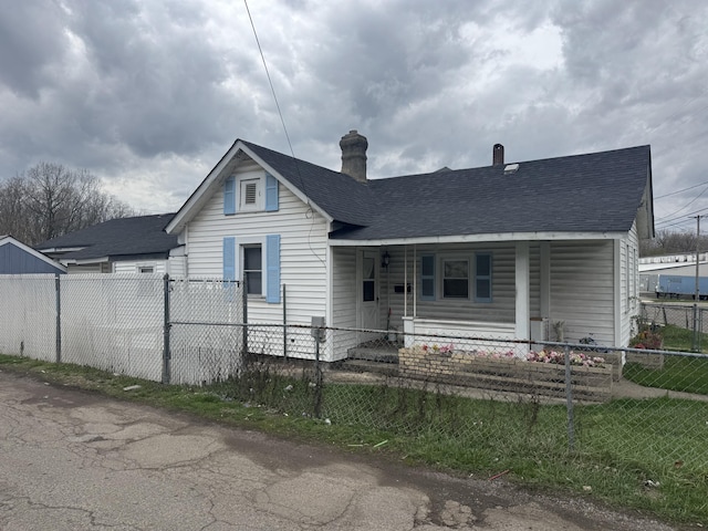 925 Sherman Ave, Springfield, OH 45503 - bungalow-style house featuring a chimney, a porch, a fenced front yard, and a shingled roof