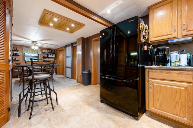 kitchen with a barn door, light carpet, light countertops, freestanding refrigerator, and recessed lighting
