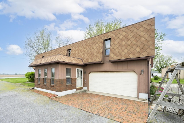 view of front facade featuring an attached garage and decorative driveway