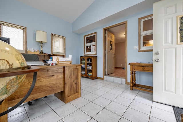 office featuring baseboards, lofted ceiling, and light tile patterned flooring