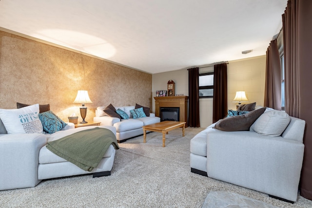 carpeted living area with concrete block wall, wallpapered walls, and a glass covered fireplace