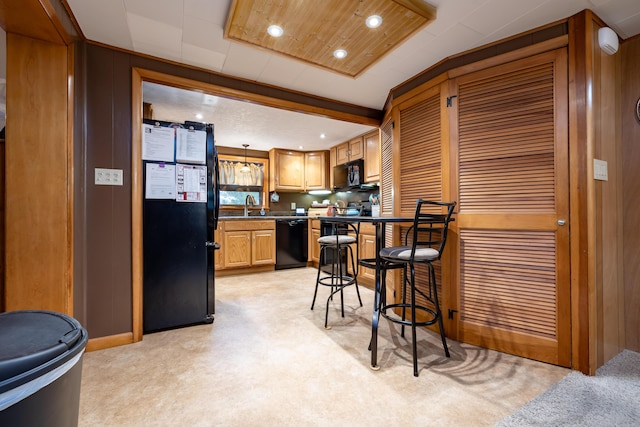 kitchen featuring pendant lighting, a sink, black appliances, light carpet, and recessed lighting