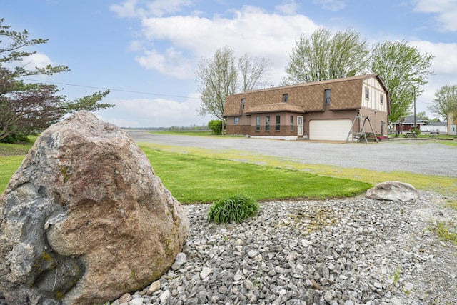 exterior space with a lawn, a garage, and gravel driveway