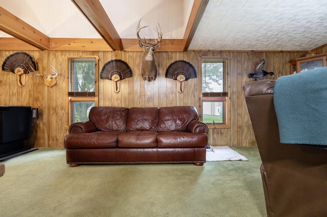 carpeted living room with wooden walls and beam ceiling