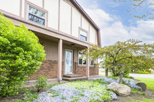 doorway to property with brick siding and stucco siding