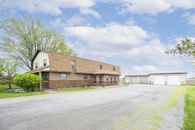 multi unit property with a detached garage, an outdoor structure, and brick siding